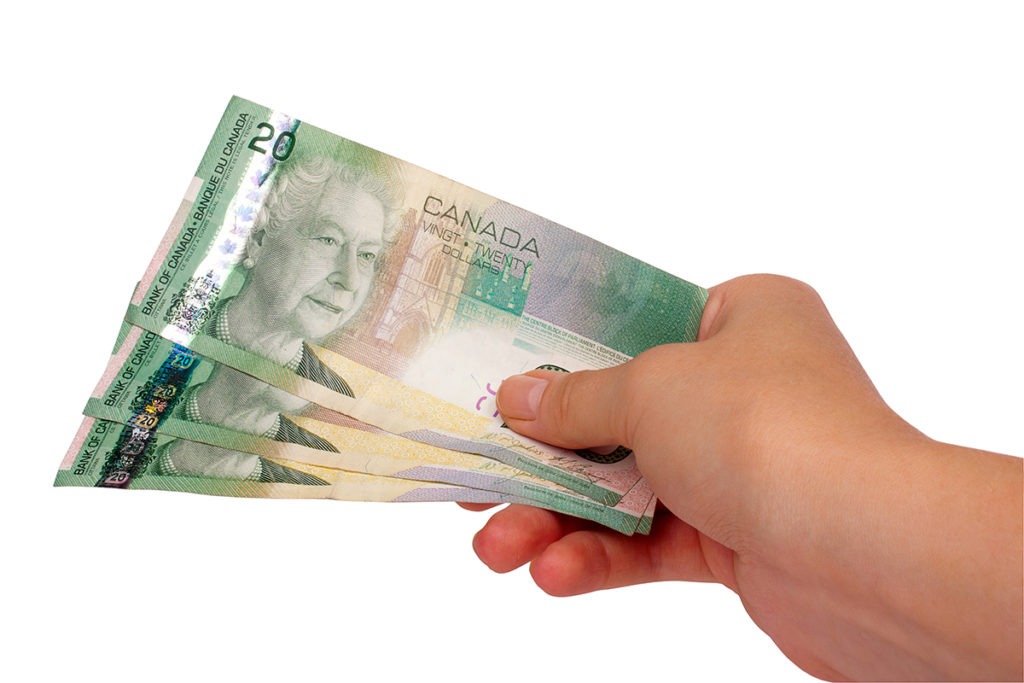 Female hand holding Canadian money