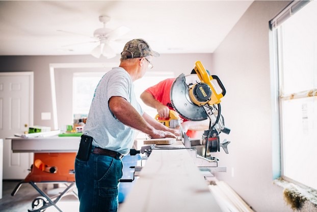 working men using a wood saw